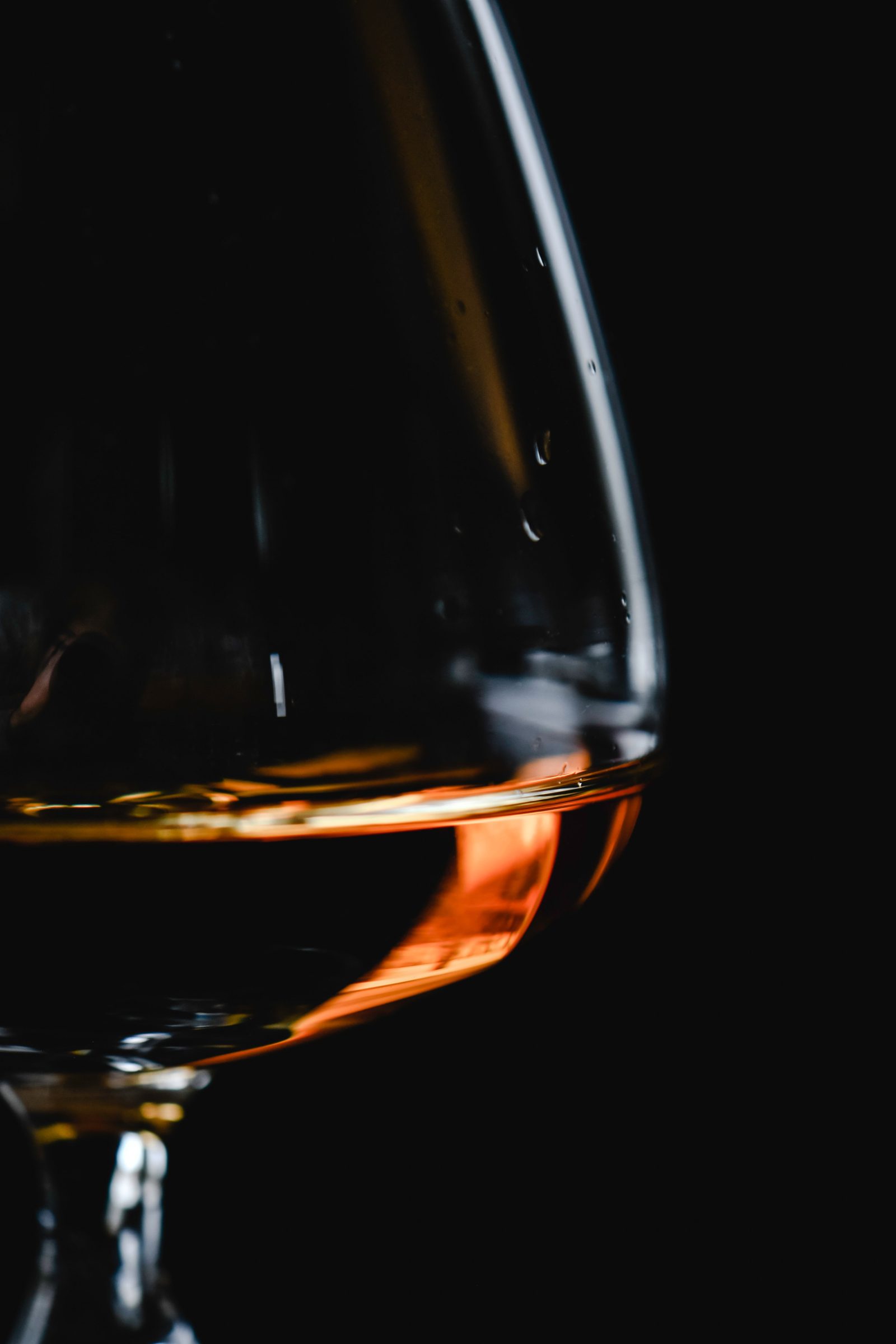 A glass of amber spirit glowing against the dark