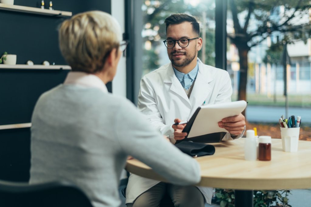 Male doctor in consultation with a woman about Facts about CoolSculpting©